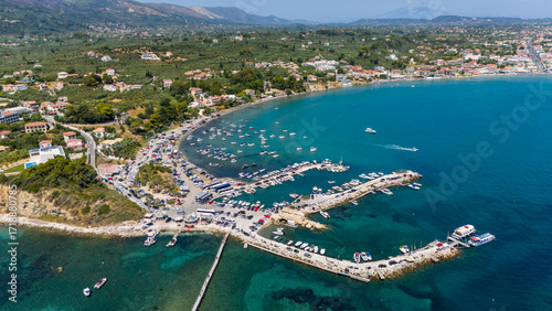Laganas Bay Zakynthos Greece aerial view with turquoise and deep blue Ionian Sea fishing boats marina coastline and seaside village houses