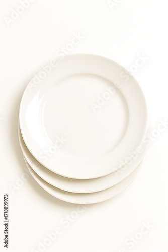 Clean stack of white ceramic dinner plates ready for serving food appetizingly