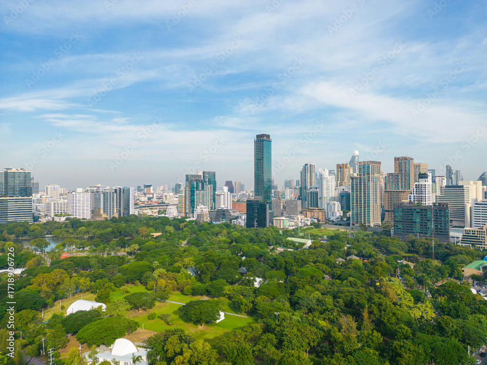 Obraz premium Aerial view green tree forest Lumpini public park with modern office building agiant blue sky cloud