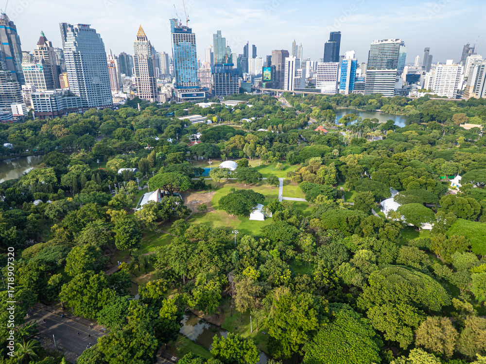 Obraz premium Aerial view green tree forest Lumpini public park with modern office building agiant blue sky cloud