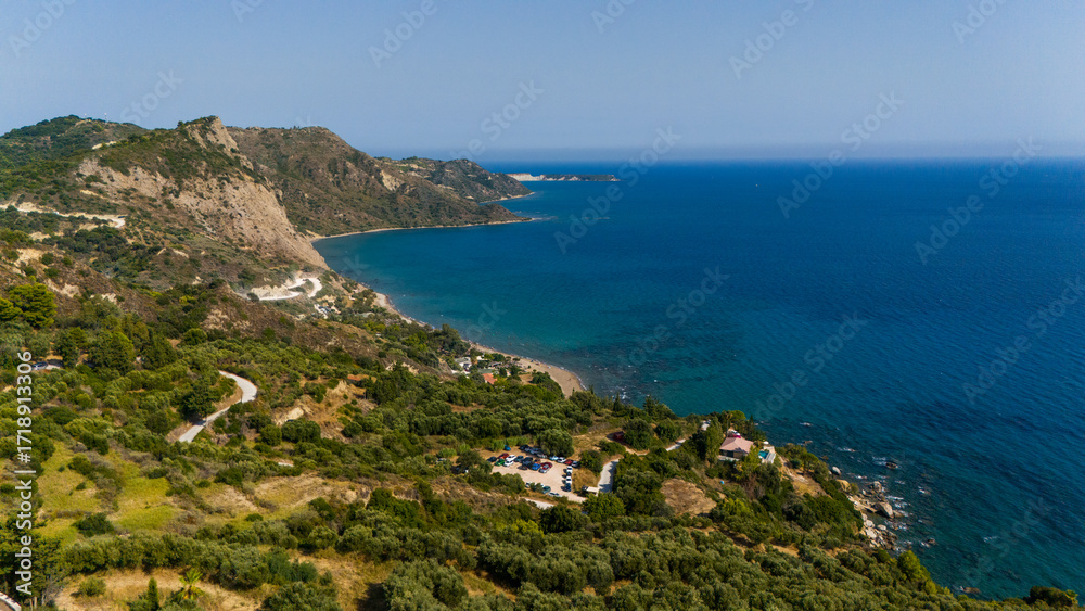Fototapeta premium Coastal cliffs and rolling hills of Zakynthos Greece meeting the endless blue Ionian Sea in a stunning aerial panorama