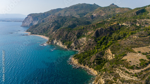 Aerial panorama of Ionian coastline featuring rugged cliffs rolling hills and secluded coves on Zakynthos island Greece