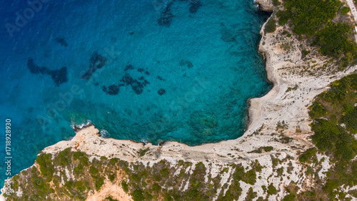 Zakynthos Greece aerial view of rocky coastline with white cliffs green vegetation and turquoise Ionian Sea showing reefs and shallow waters