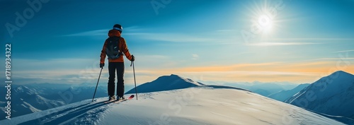 Skier Enjoys Breathtaking View at Mountain Peak During Sunset With Clear Blue...