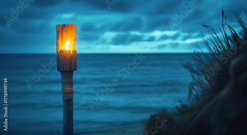 Tiki Torch Burning at Sunset on a Serene Beach With Gentle Waves.