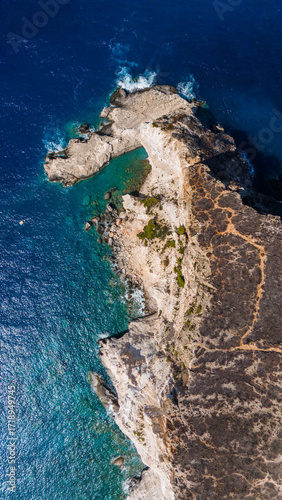 Plakaki beach Zakynthos Greece top down aerial showing dramatic rocky headland turquoise shallow waters and deep blue sea surrounding coastline