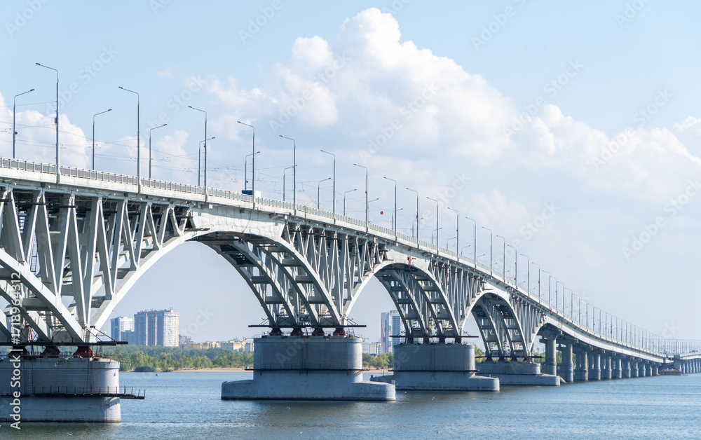 Naklejka premium The bridge through the river Volga. Saratov.The bridge over the Volga River between the cities of Saratov and Engels. Panorama of the city and the Saratov bridge across the Volga river. Russia.
