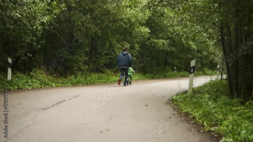 Wallpaper Mural Child wearing safety helmet experiences first bicycle ride while father runs alongside providing security and encouragement during learning. Torontodigital.ca