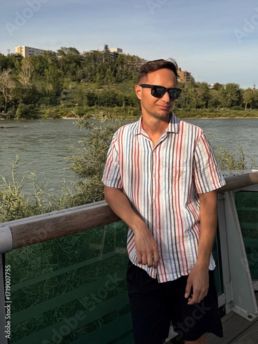 Portrait of handsome mature man standing on river bank