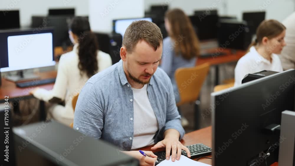 Man student of computer courses types on keyboard, performs work ...