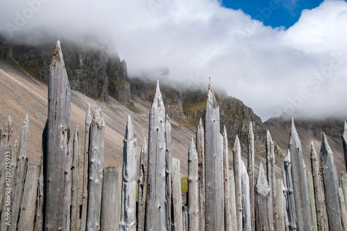 Vestrahorn Iceland, wooden palisade or stakewall with craggy mountain top in background
