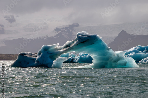Jokulsarlon iceland, melting iceberg on lagoon with mountains in background