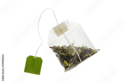 A single tea bag filled with loose green tea leaves, isolated on a transparent background. background removed