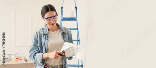 Young woman with putty kniv...