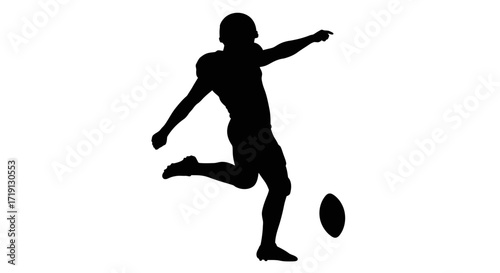 Silhouette of a football player kicking a football