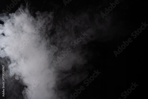 White smoke cloud on a black background, abstract texture of vapor or fog, concept of mystery, atmosphere, pollution, or stage effect.