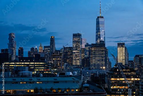 View of the city's skyscrapers illuminated against the darkening sky, with buildings casting long shadows, creating a captivating contrast of light and shadow, New York, New York, United States.