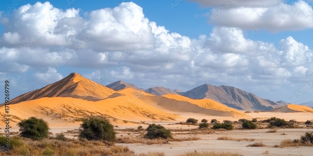 Fototapeta premium Endless Waves of Golden Sand Dunes Under a Bright Blue Sky with Fluffy White Clouds Above