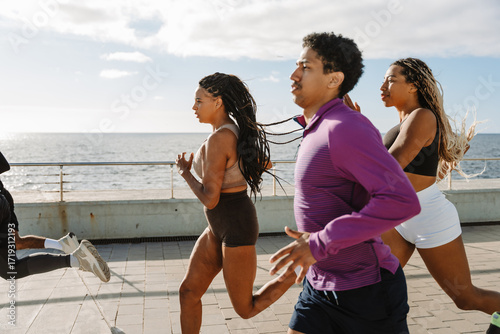 A group of three athletes running behind two athletes