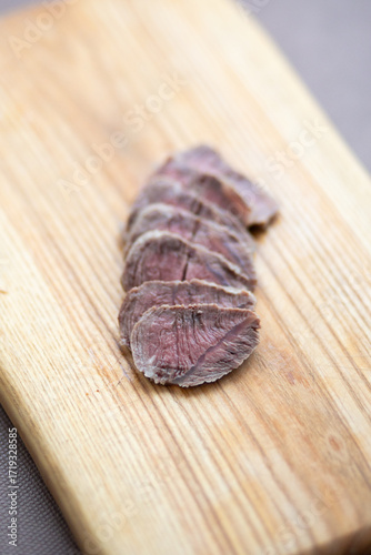 Thin slices of freshly cooked beef for small dogs - feeding animals with natural food