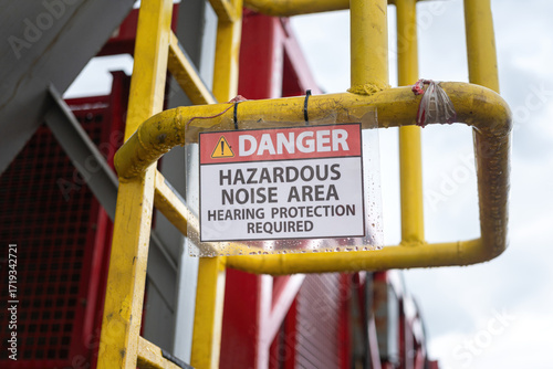 High noise working area warning, required to wear hearing protection. The safety sign at industrial refinery process plant. 