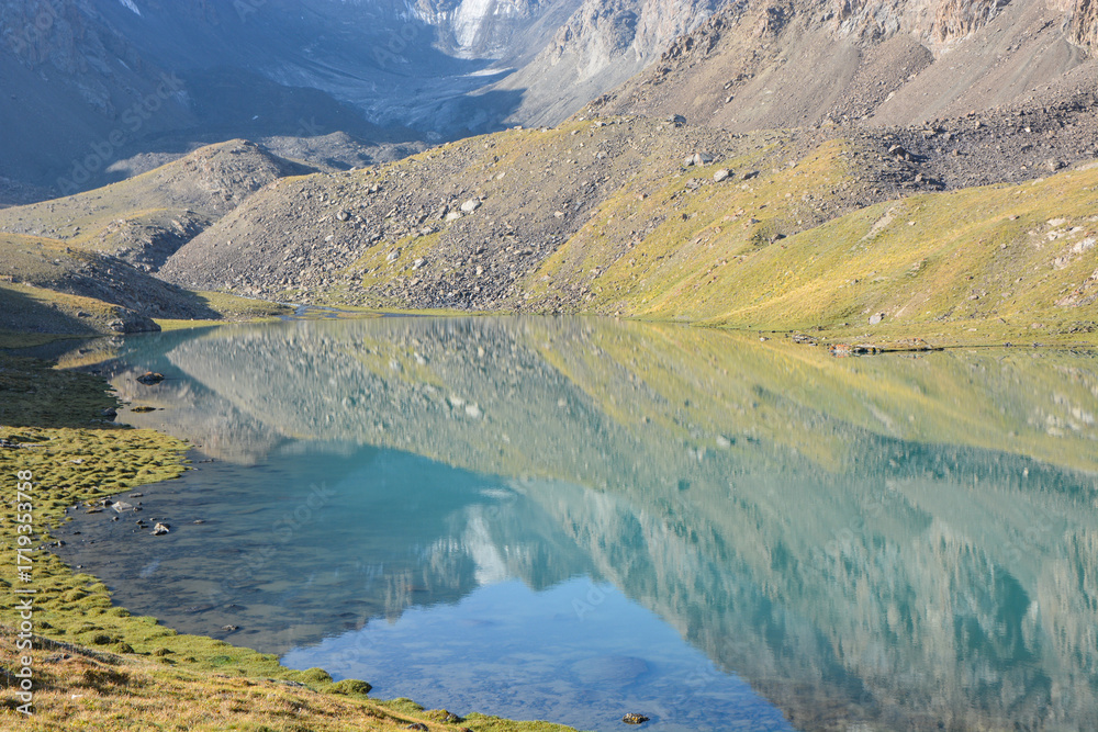Fototapeta premium Idyllic summer landscape with hiking trail in the mountains with beautiful fresh green mountain pastures, lake with reflection. Alai ridge mountains