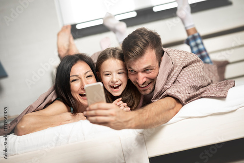 Young smiling family take selfie.