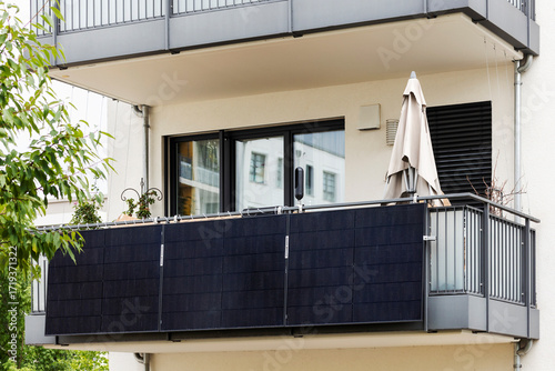 Balcony Solar Panel Energy System. Modern Balcony with Solar Station on Balcony Railing of Residential Apartment Building.