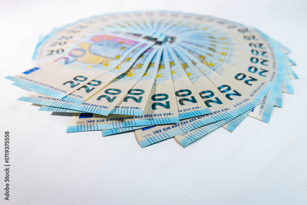 Fototapeta premium Circular arrangement of 20 euro banknotes spread out like a fan on a white background, symbolizing finance, savings, and monetary wealth.