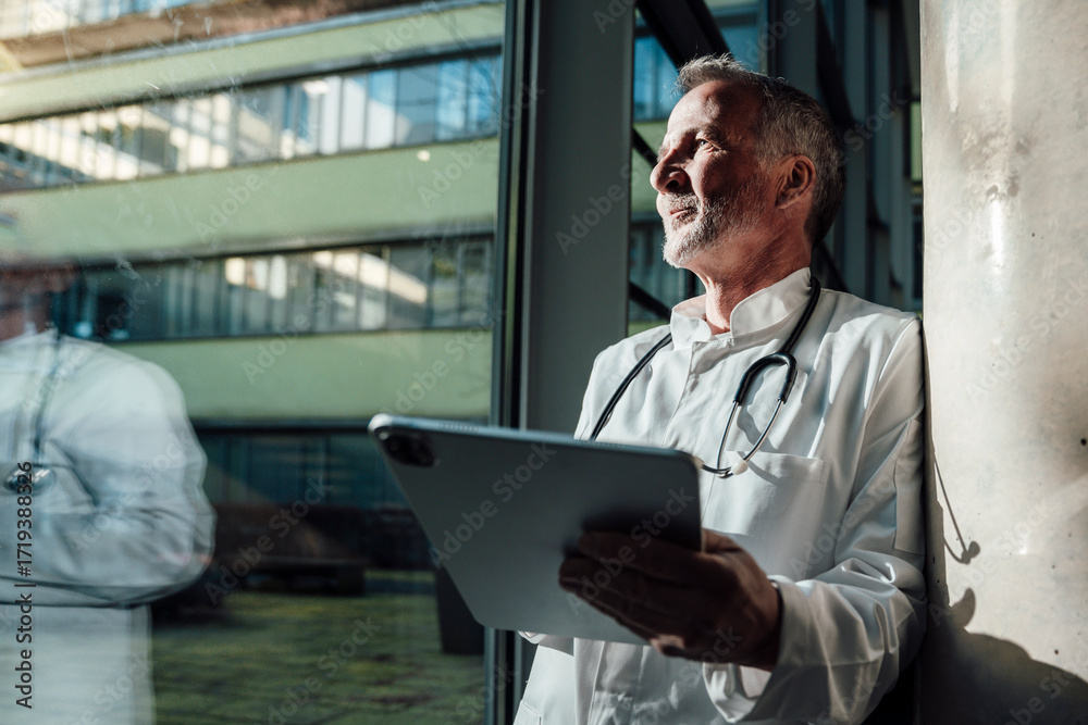 © Westend61 - Doctor with stethoscope using tablet looking thoughtfully by window © Westend61 - Doctor with stethoscope using tablet looking thoughtfully by window