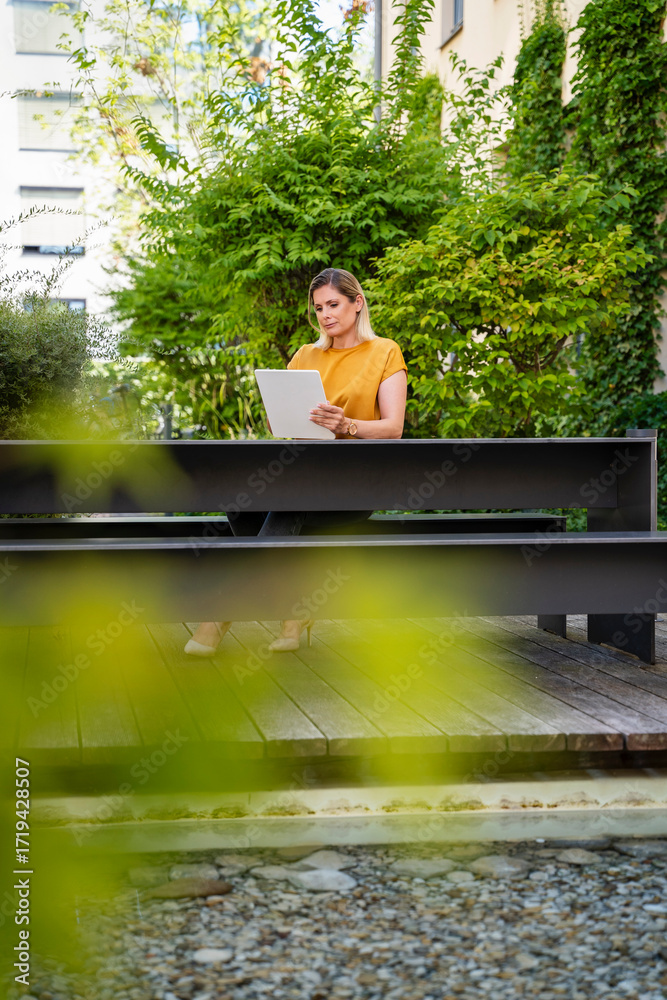 © Westend61 - Businesswoman using tablet PC on table near plants © Westend61 - Businesswoman using tablet PC on table near plants