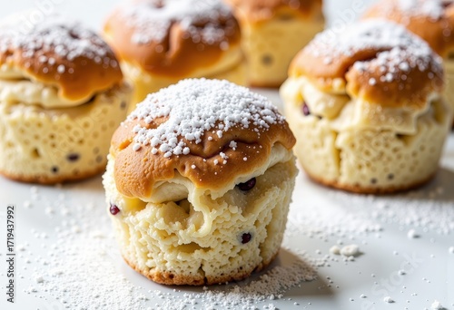 Delicious homemade muffins topped with a generous dusting of powdered sugar, showcasing a golden brown crust and soft, moist interior with visible ingredients inside