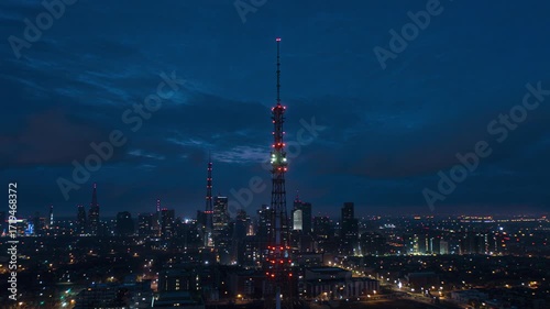 Wallpaper Mural Television tower stands tall over the illuminated city skyline at night, creating a striking contrast against the dark sky and showcasing urban architecture. Torontodigital.ca