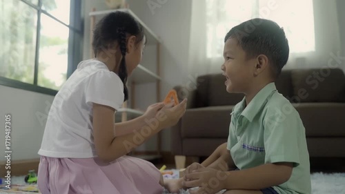Girls and boys are playing with toys in the room, and the children are playing with colorful toys on the carpet on the floor.