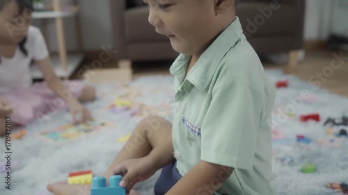 Girls and boys are playing with toys in the room, and the children are playing with colorful toys on the carpet on the floor.