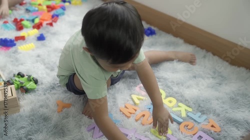 boys are playing with toys in the room, and the children are playing with colorful toys on the carpet on the floor.