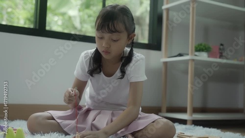 Girls  playing with toys in the room, and the children are playing with colorful toys on the carpet on the floor.