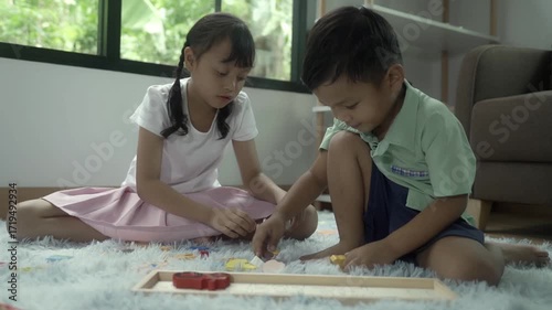 Girls and boys are playing with toys in the room, and the children are playing with colorful toys on the carpet on the floor.