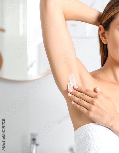Woman applying underarm cream in bathroom