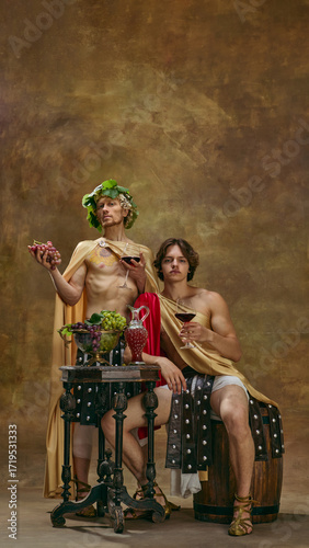 Photography Two men in Roman costumes with grapes and wine at festive banquet table
