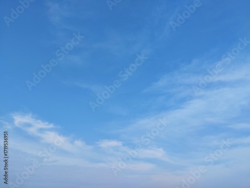 clear blue sky with a few clouds. The sky is very bright and the clouds are scattered throughout