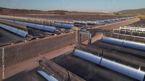 Solar thermal power plant with parabolic mirrors in a dry landscape. Renewable energy technology for clean electricity production and environmental sustainability.