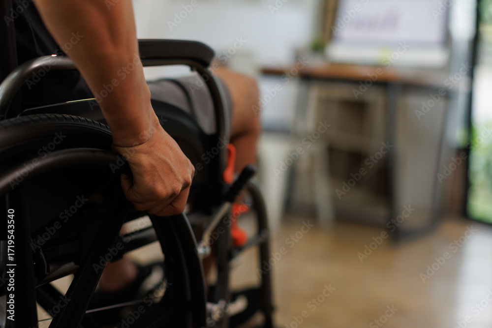 Obraz premium diseased man is sitting in a wheelchair, He holds his hands on the wheel wheelchair Recovery and healthcare concepts. 