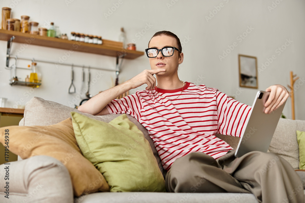 Obraz premium Charming young man enjoys a cozy afternoon while contemplating on the couch