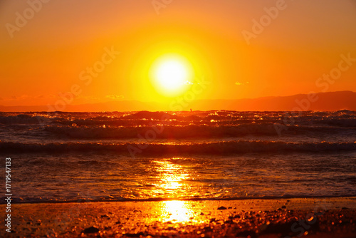 湘南の波に挑むサーファーと夕焼けの海｜広告やSNSに最適な夏の風景