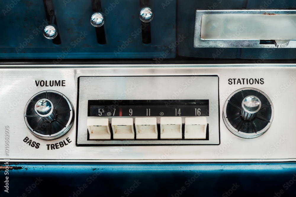 Fototapeta premium Retro styled image of an old car radio inside a blue classic American car