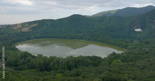 Aerial view of the Monticchio lakes, located in the craters of the ancient extinct volcano Monte Vulture. They are located in the province of Potenza, Basilicata, Italy, and are surrounded by trees.