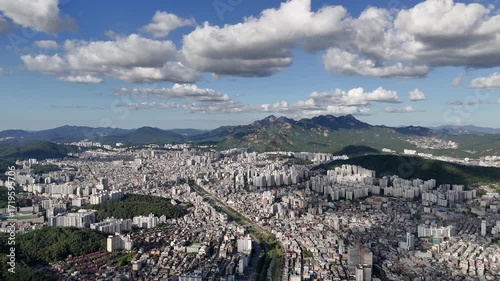 A Sprawling Seoul Cityscape with Mountains and a Bright Sky