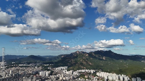 A Sprawling City at the Base of a Mountain Range Under a Cloudy Sky