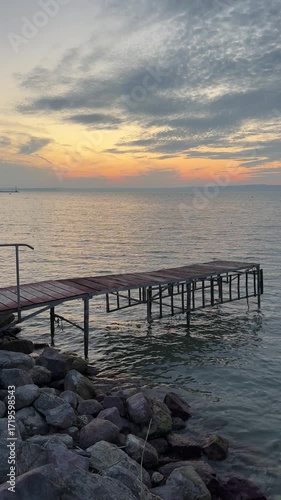 Sunset on the shore of Lake Balaton in Siofok Hungary with  wooden pier vertical